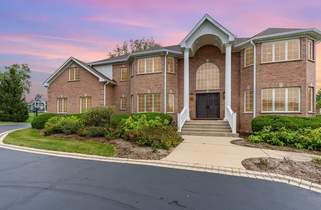 a front view of a house with a yard and trees