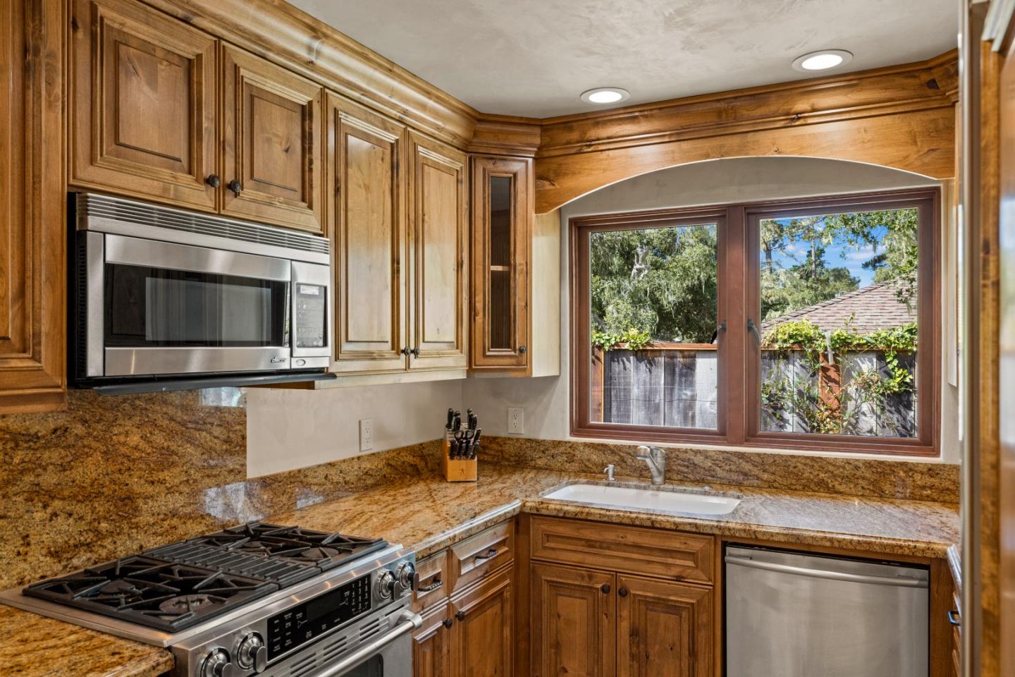 1156 Arroyo Drive Pebble Beach, CA 93953 - Photo 14 of 42 a kitchen with stainless steel appliances granite countertop a stove a sink and a microwave