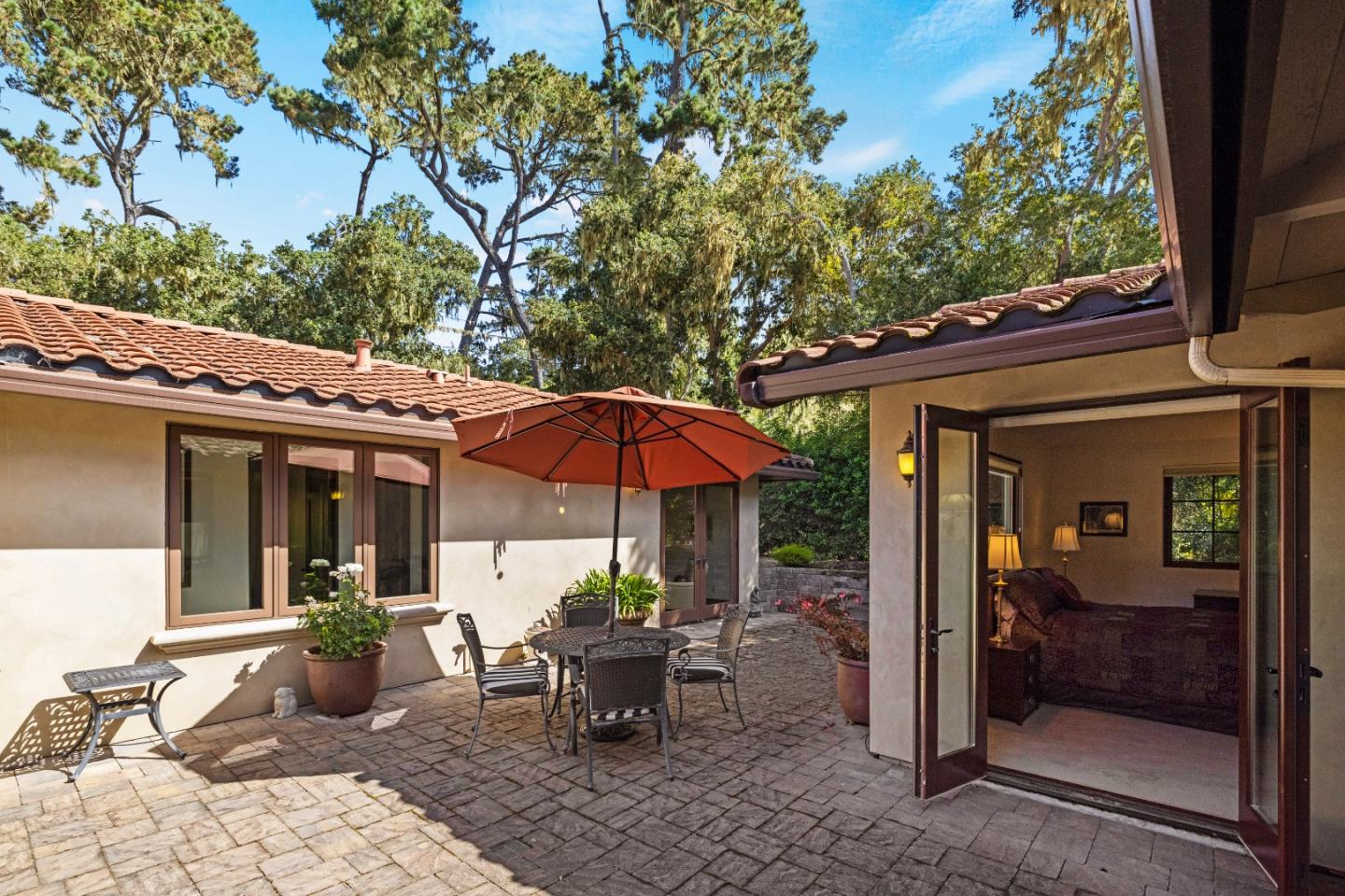1156 Arroyo Drive Pebble Beach, CA 93953 - Photo 23 of 42 a view of a patio with a table and chairs under an umbrella