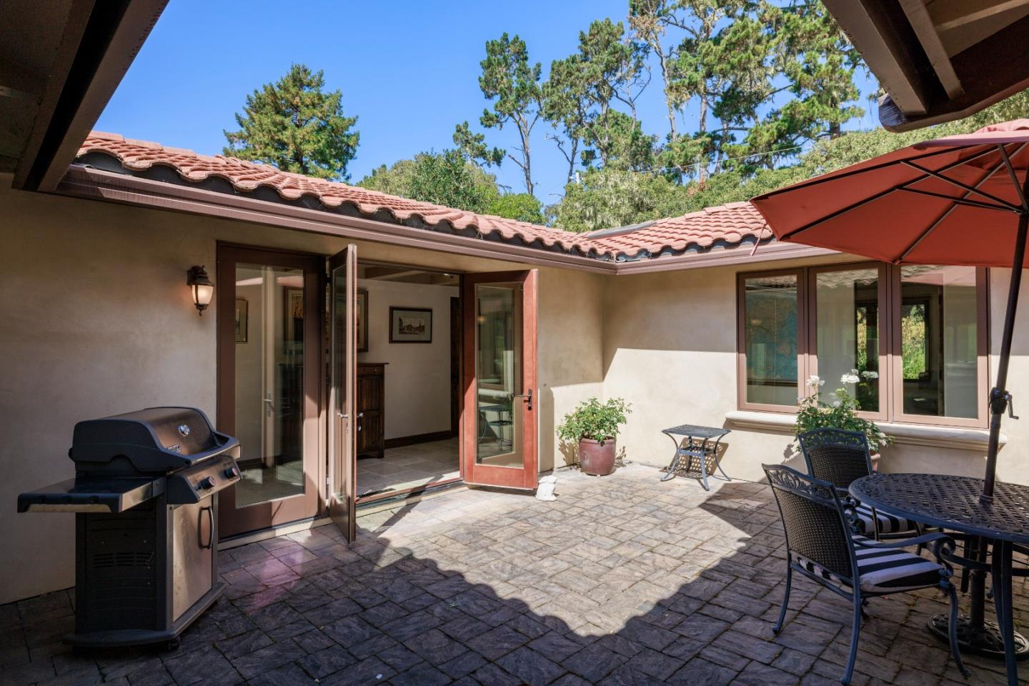 1156 Arroyo Drive Pebble Beach, CA 93953 - Photo 25 of 42 a view of a patio with table and chairs and potted plants