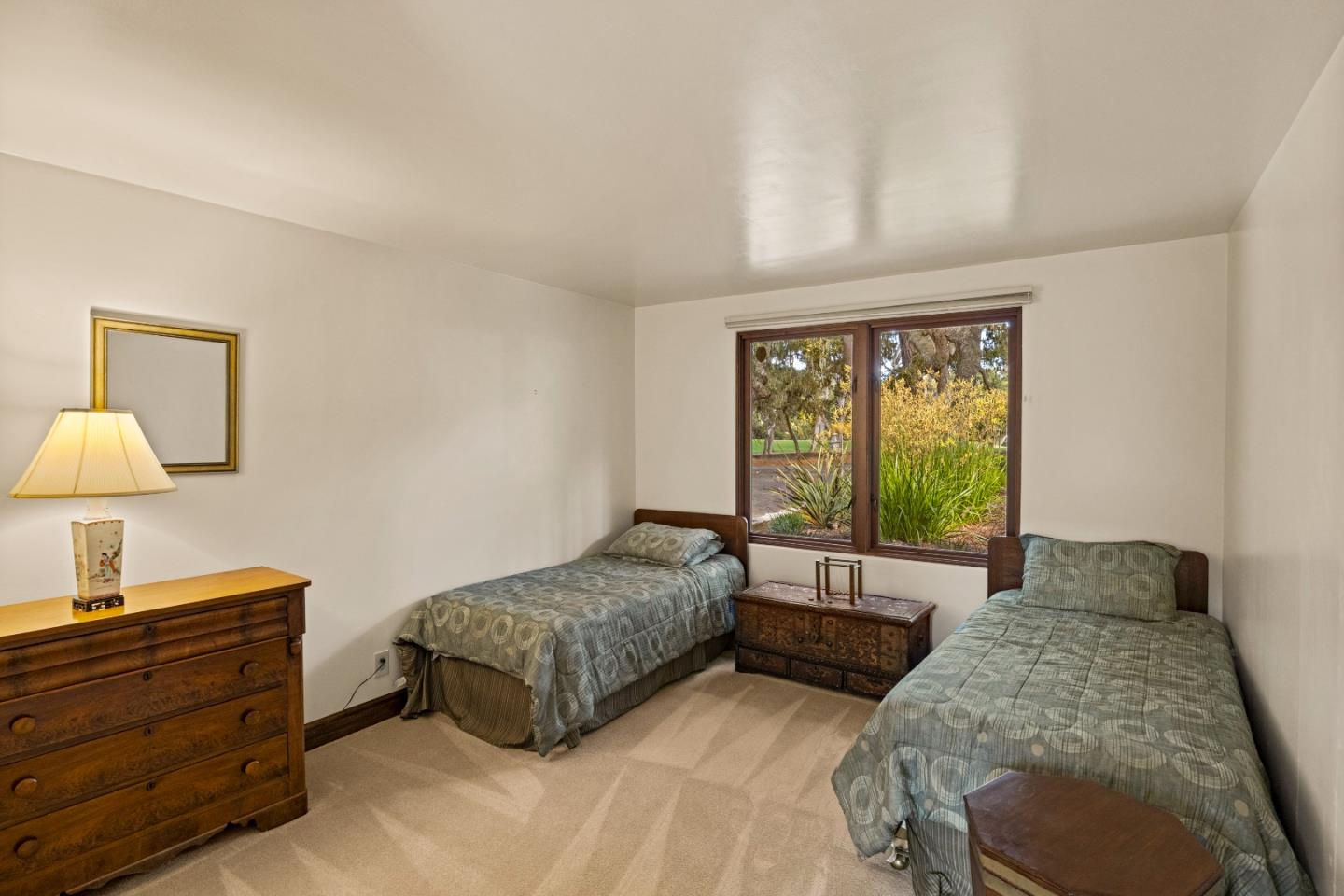 1156 Arroyo Drive Pebble Beach, CA 93953 - Photo 32 of 42 a spacious bedroom with a bed and a lamp
