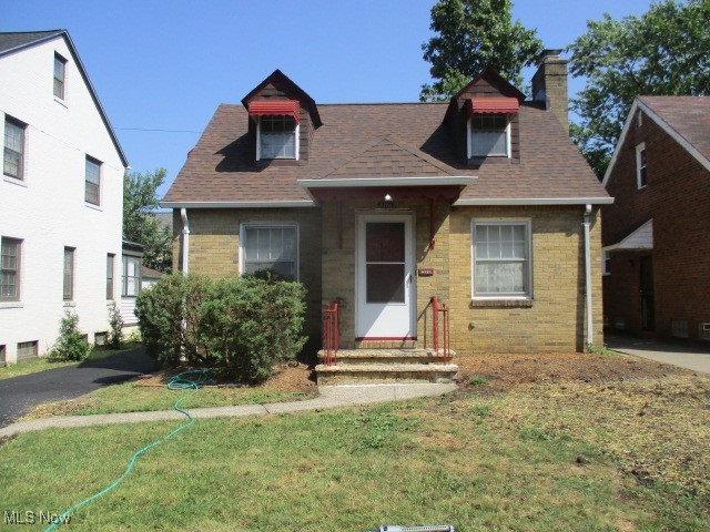 3703 Bainbridge Road Cleveland Heights, OH 44118 - Photo 2 of 16 View of front of property with a chimney, a front yard, a shingled roof, and brick siding