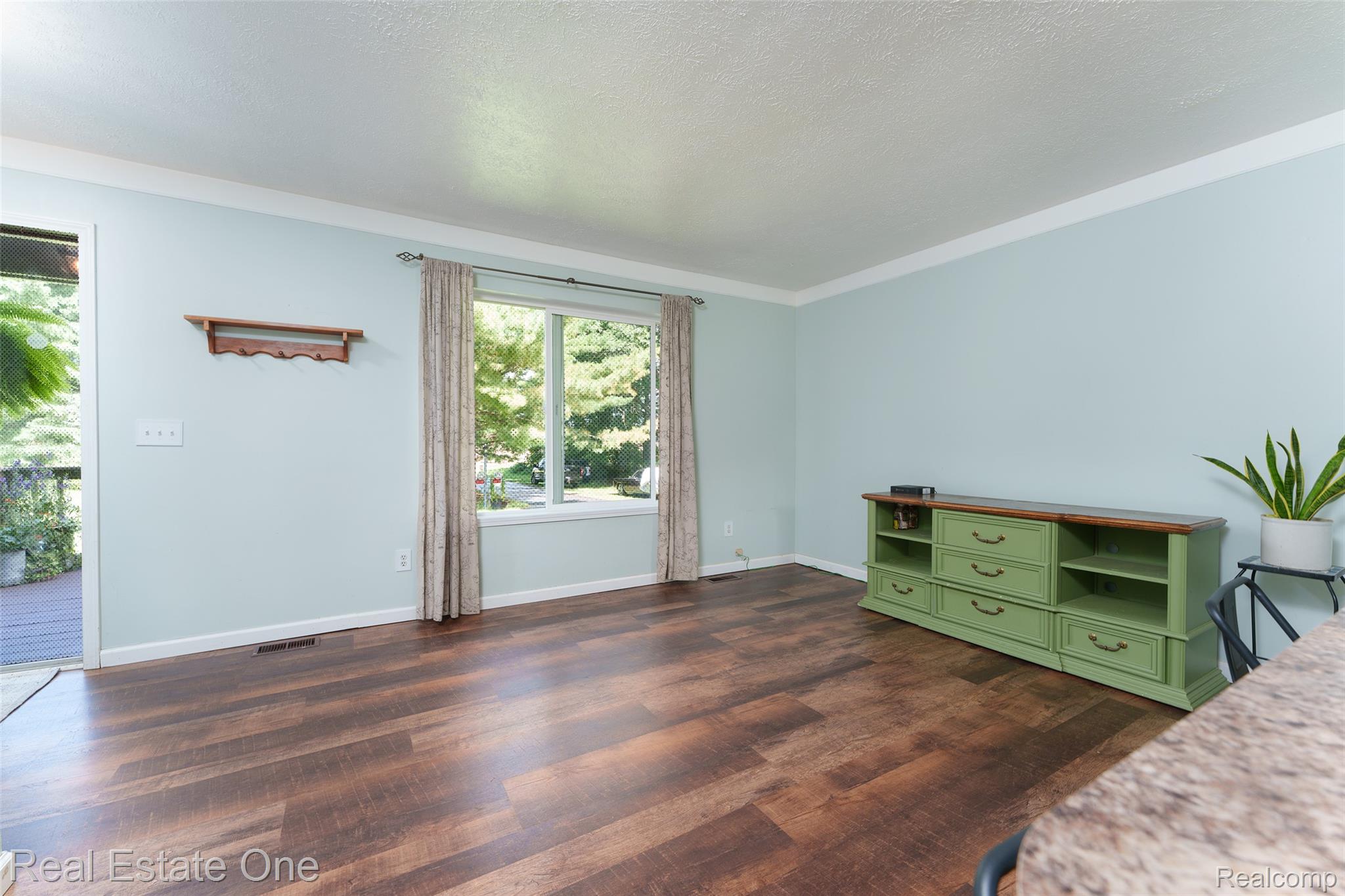 5130 Iosco Road Webberville, MI 48892 - Photo 18 of 39 Wood-finish flooring, light-toned wall paint, white trim, and a prominent window