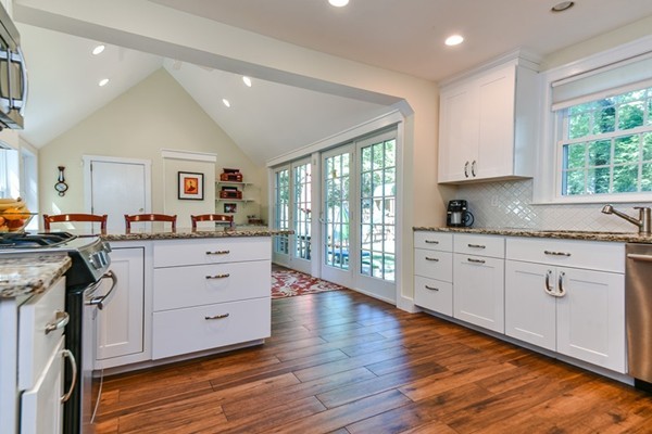 45 Earle Road Wellesley, MA 02481 - Photo 2 of 16 a open kitchen with granite countertop a stove top oven a sink and white cabinets with wooden floor