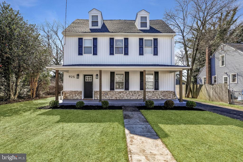 Charming two-story home with lush greenery.