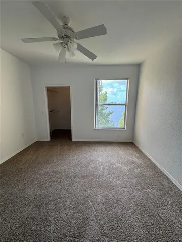 an empty room with a ceiling fan and a window
