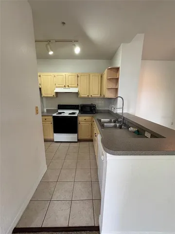 a kitchen with stainless steel appliances granite countertop a sink a stove and a refrigerator