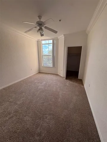 an empty room with a ceiling fan and a window
