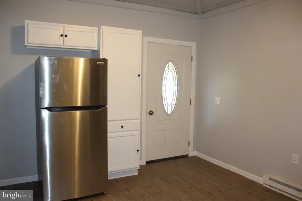 an empty room with wooden floor cabinet and closet