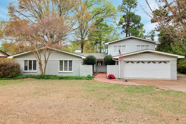 a view of a house with yard and large tree