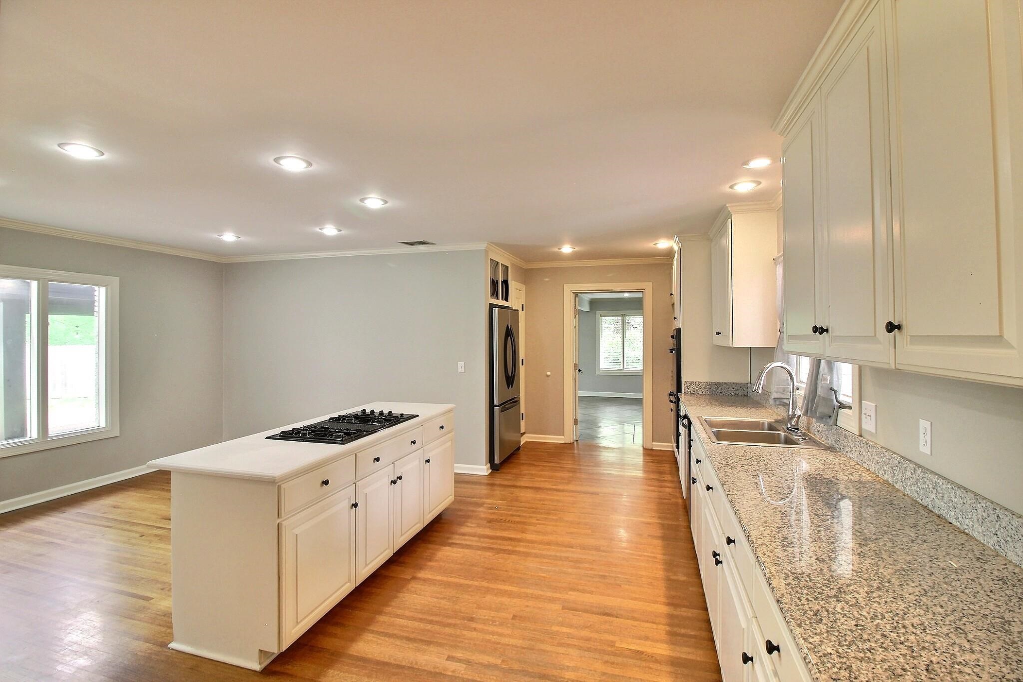 7572 Willey Road Germantown, TN 38138 - Photo 11 of 30 a large white kitchen with lots of counter top space and wooden floor