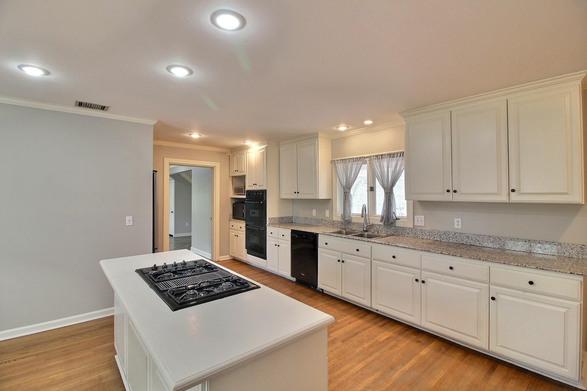 7572 Willey Road Germantown, TN 38138 - Photo 10 of 30 a kitchen with granite countertop a sink stainless steel appliances and white cabinets