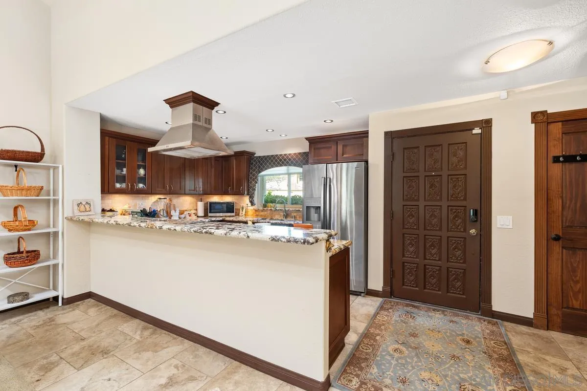 17442 Port Marnock Drive Poway, CA 92064 - Photo 6 of 28 a kitchen with kitchen island a stove a refrigerator and cabinets