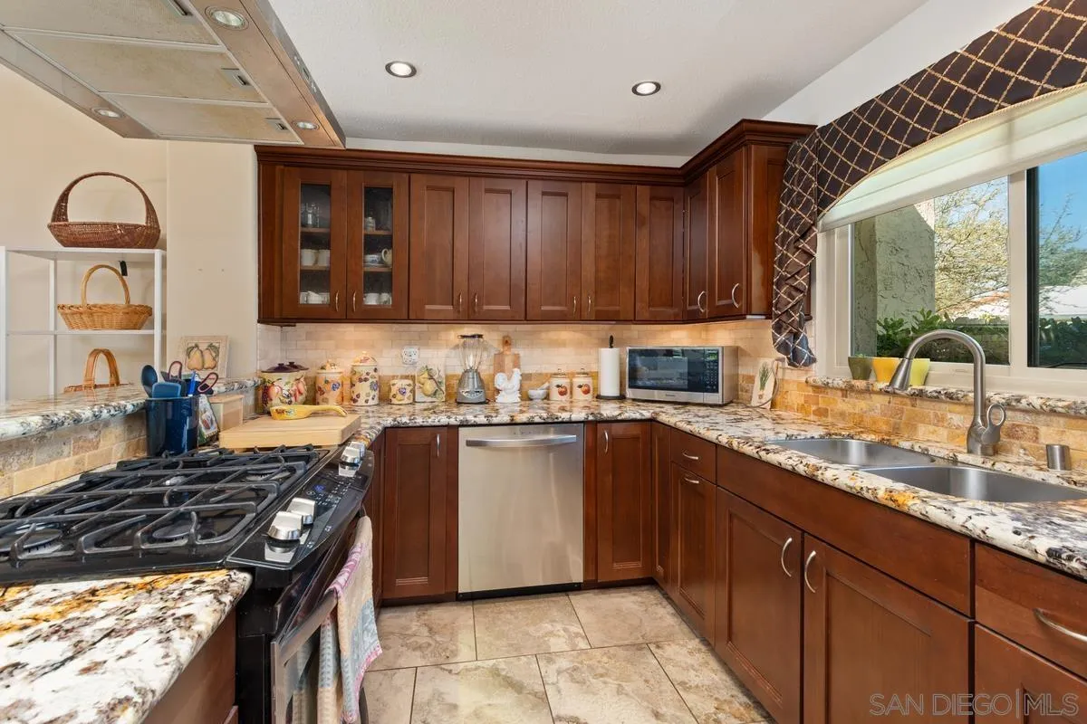 17442 Port Marnock Drive Poway, CA 92064 - Photo 7 of 28 a kitchen with stainless steel appliances granite countertop a sink stove and cabinets