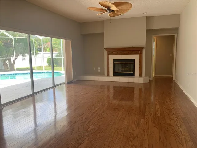 a view of a livingroom with wooden floor a fireplace and window