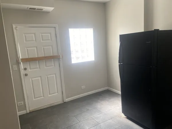 a kitchen with white cabinets and black appliances