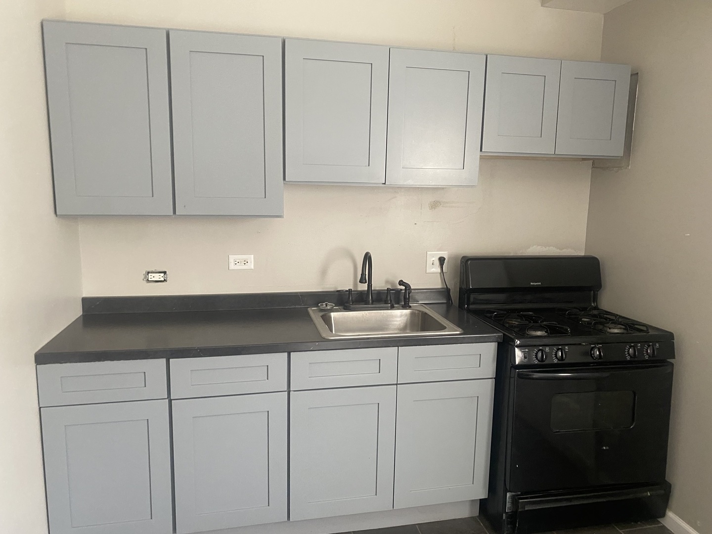1253 West 80th Street, Unit 2E Chicago, IL 60620 - Photo 7 of 10 a kitchen with white cabinets and black appliances