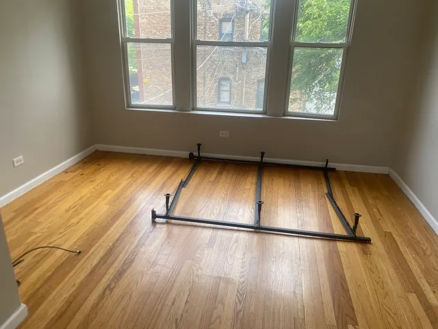 a view of a room with wooden floor and a window