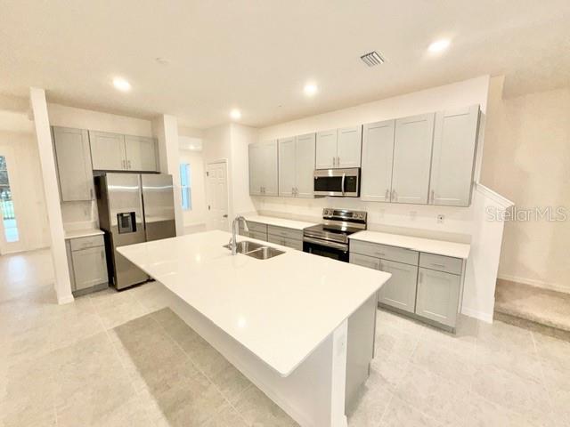 1463 Alston Bay Boulevard Apopka, FL 32703 - Photo 8 of 19 a kitchen with a refrigerator a stove top oven and white cabinets