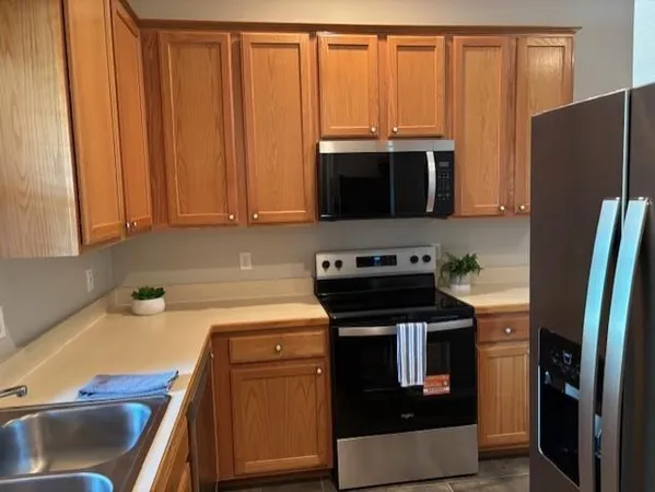 a kitchen with stainless steel appliances a stove a microwave and a sink