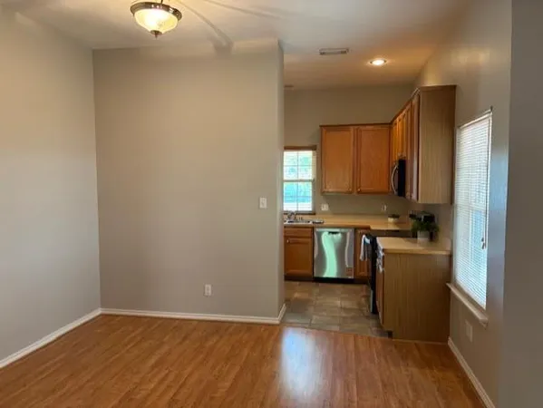 a kitchen with a refrigerator a stove top oven and wooden floor