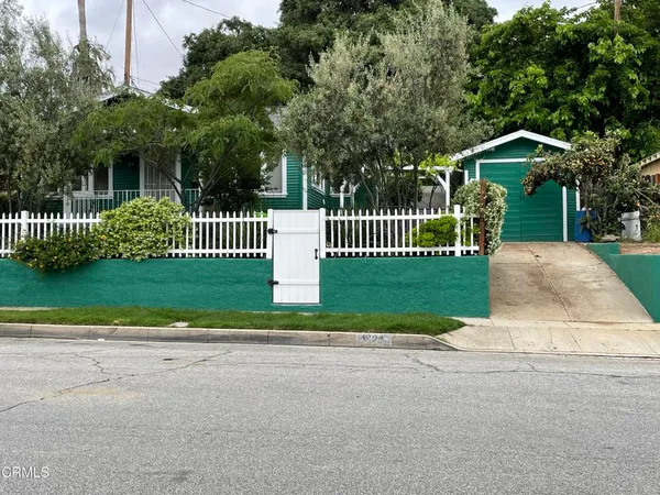 a front view of a house with a garden and plants