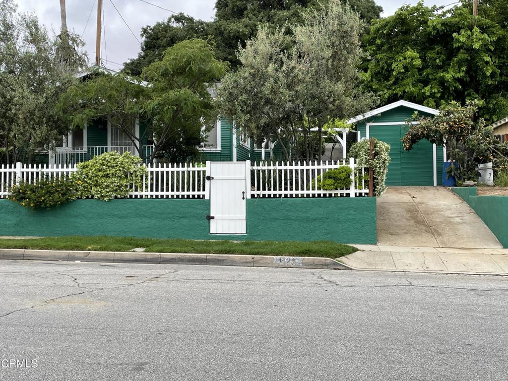 a front view of a house with a garden and plants