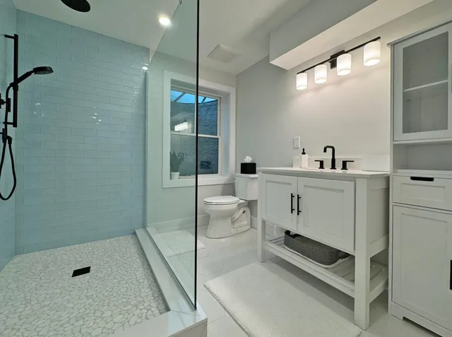 a bathroom with a sink a toilet and shower