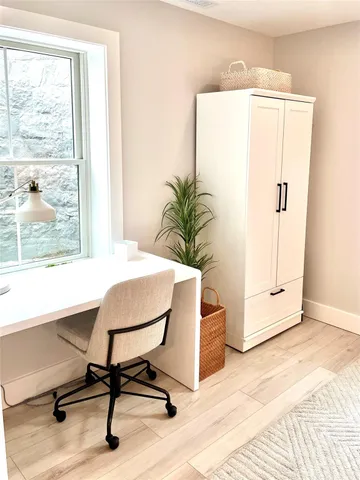 a view of a workspace with furniture and a window