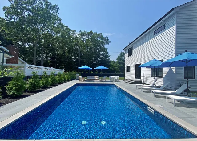 a view of a house with swimming pool and sitting area