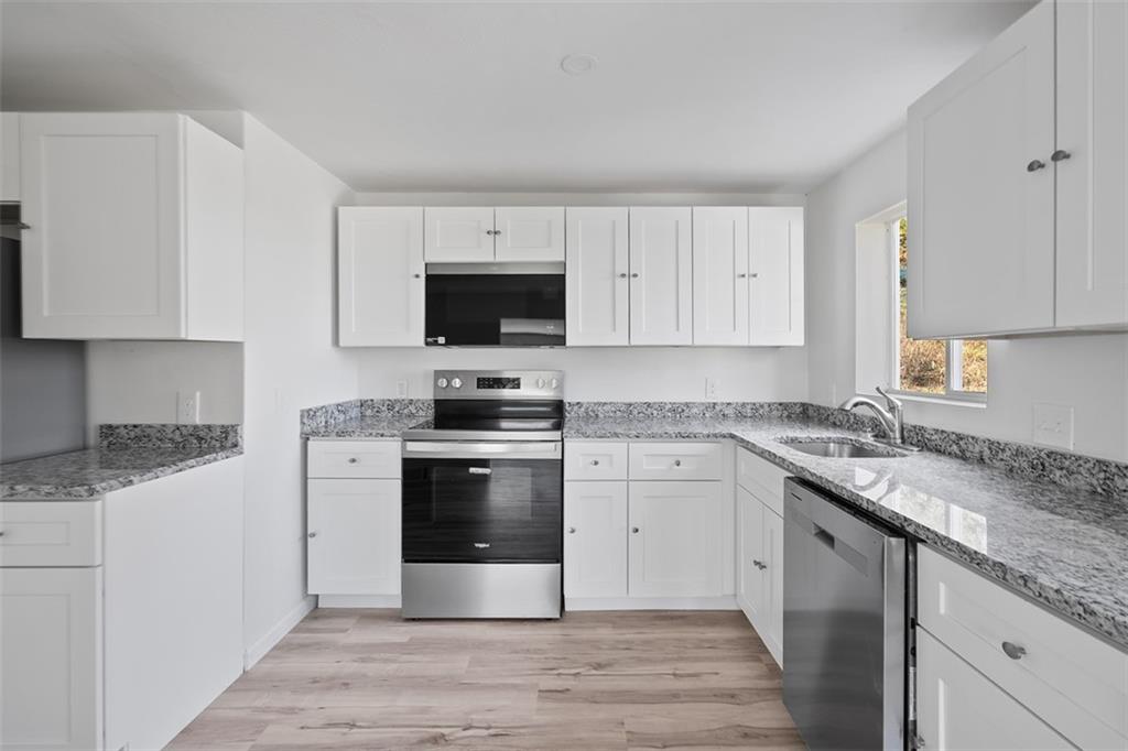 1460 Guffey Road Irwin, PA 15642 - Photo 11 of 33 a kitchen with stainless steel appliances granite countertop a stove a sink and a microwave