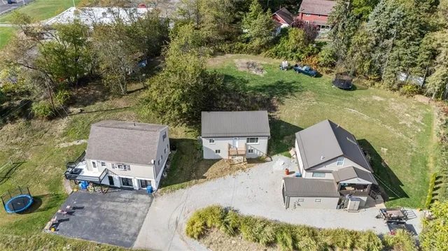 an aerial view of a house with a yard and lake view