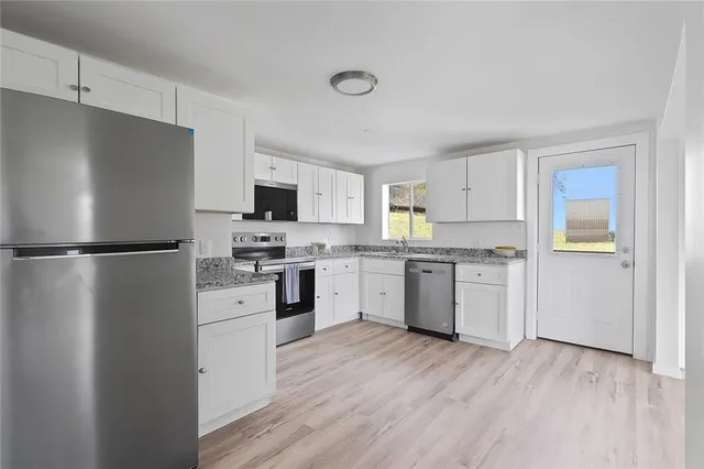 a kitchen with a refrigerator a stove top oven a sink and cabinets
