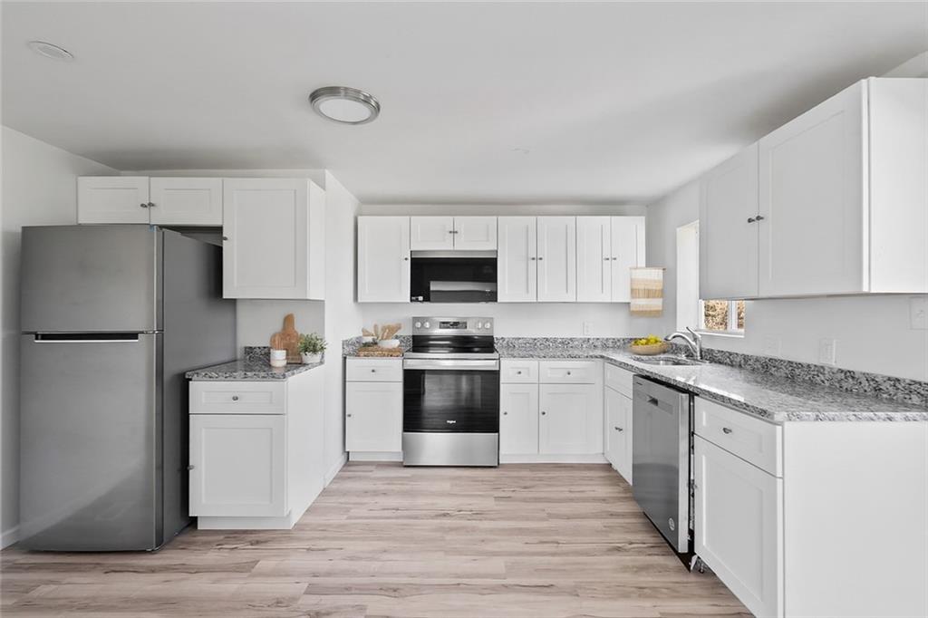 1460 Guffey Road Irwin, PA 15642 - Photo 9 of 33 a kitchen with granite countertop white cabinets and white appliances
