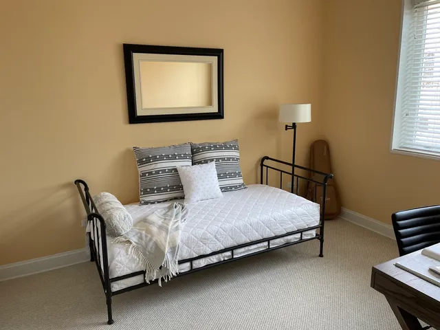 a bedroom with a bed lamp and a window