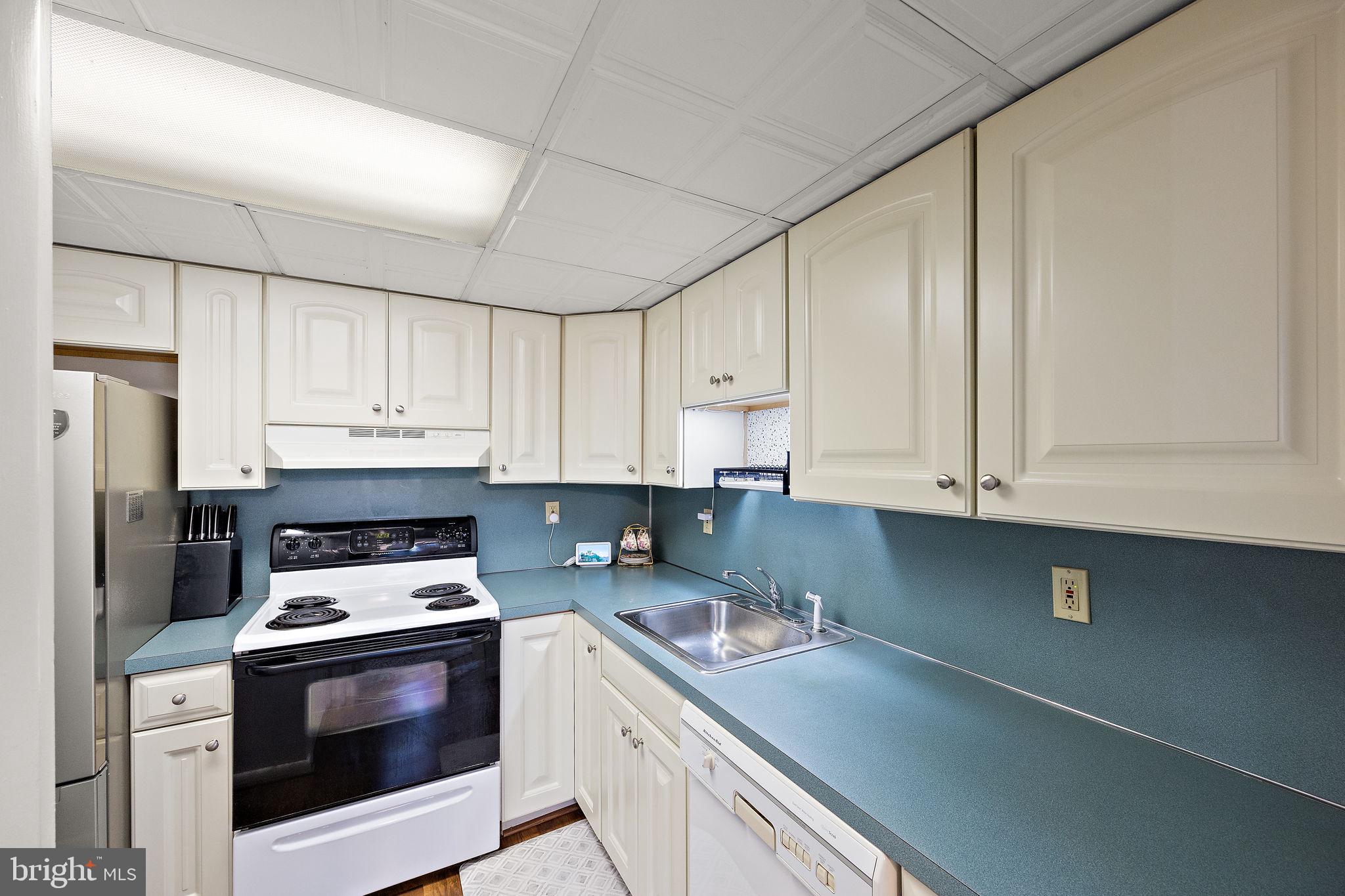 117 Railroad Avenue, Unit A7 West Grove, PA 19390 - Photo 11 of 27 a kitchen with granite countertop white cabinets and white appliances