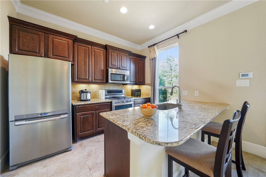 26250 Riley Road Waller, TX 77484 - Photo 11 of 14 a kitchen with granite countertop a refrigerator a stove a kitchen island a dining table and chairs