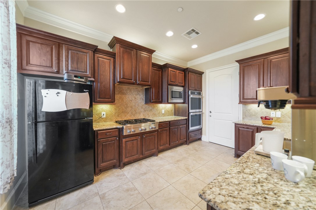 26250 Riley Road Waller, TX 77484 - Photo 9 of 14 a kitchen with stainless steel appliances granite countertop a refrigerator stove and oven