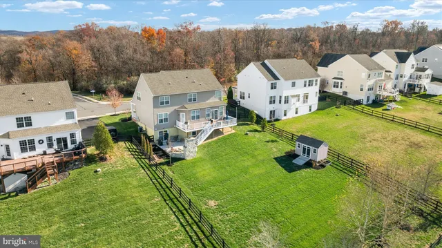 an aerial view of a house with swimming pool and large trees