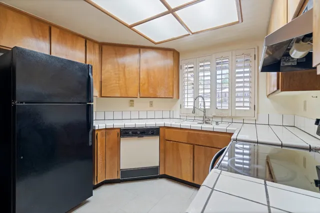 a kitchen with stainless steel appliances granite countertop a refrigerator a sink and a stove