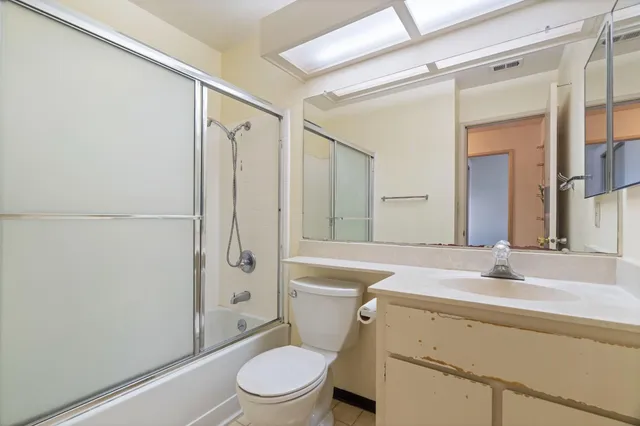 a bathroom with a sink a toilet a mirror and shower