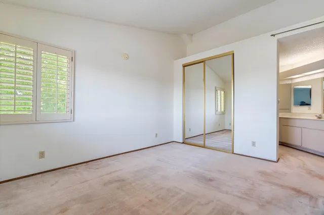 an empty room with windows and closet