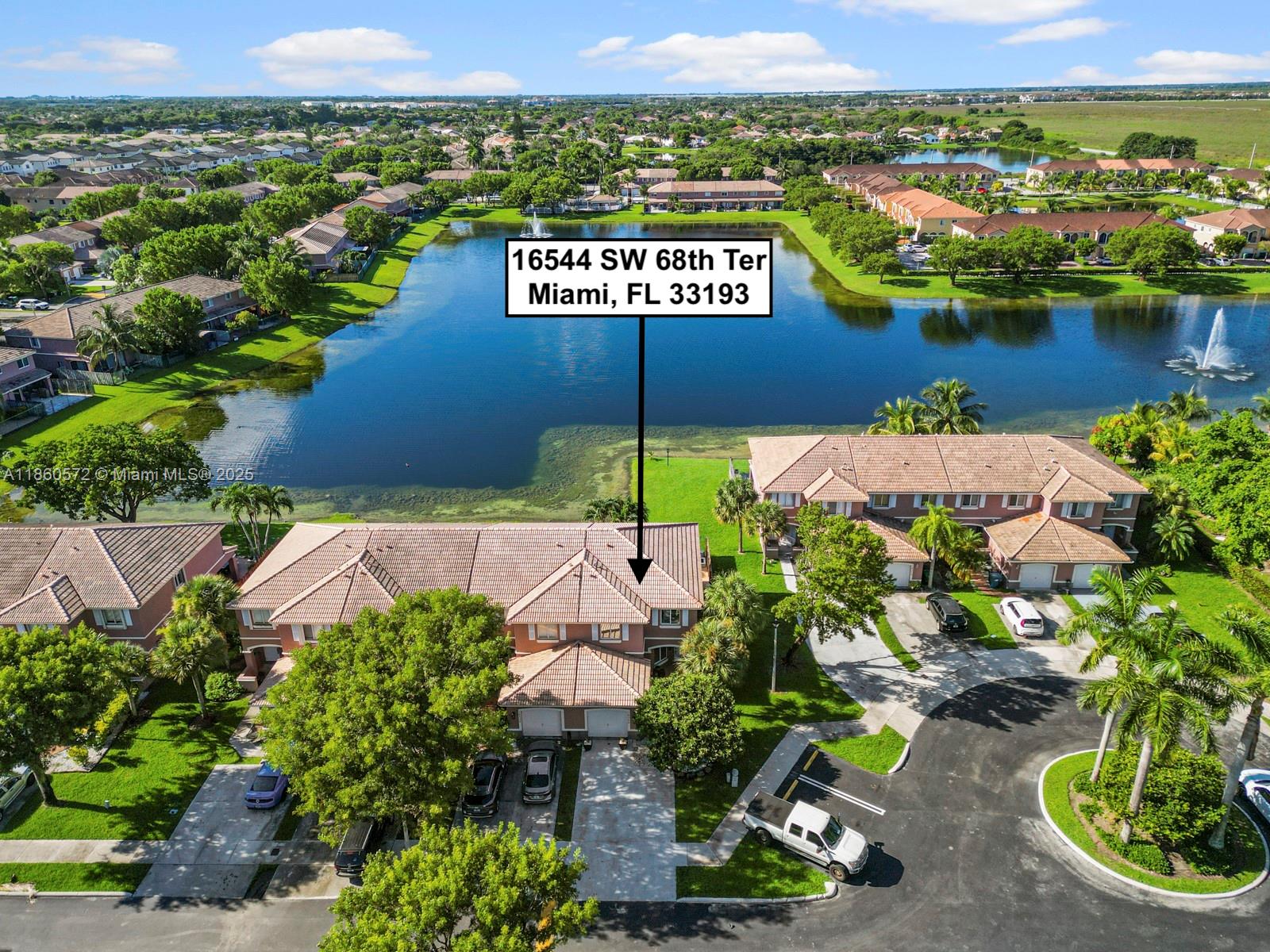 an aerial view of a house with a garden and lake view