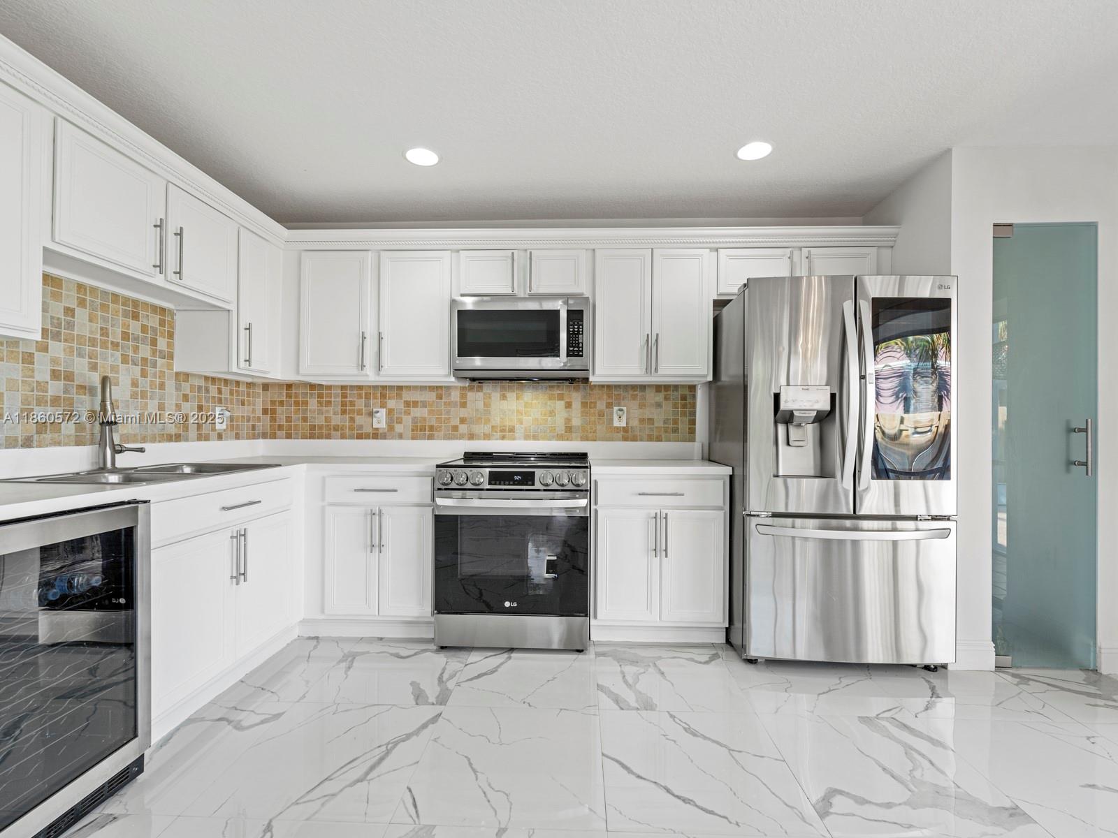 16544 Southwest 68th Terrace Miami, FL 33193 - Photo 15 of 32 a kitchen with a refrigerator stove and sink