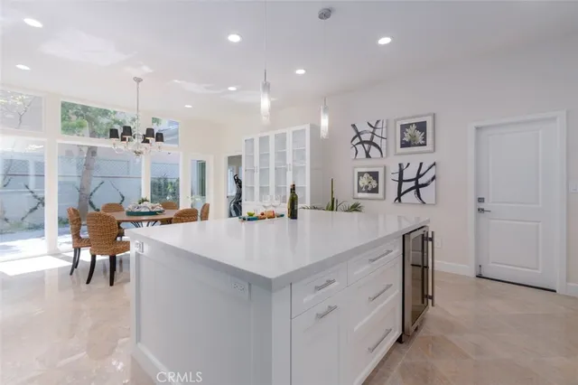 a large kitchen with kitchen island a sink a stove a dining table and chairs