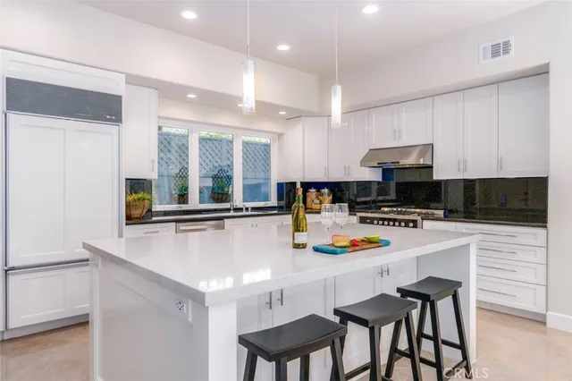 a kitchen with a sink a stove and chairs