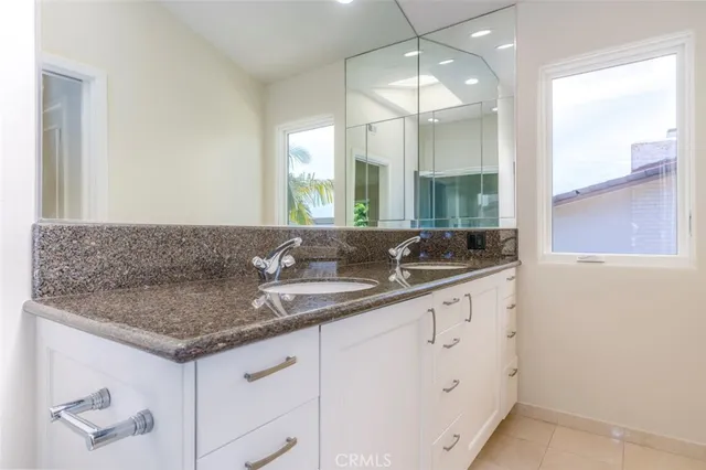 a bathroom with a granite countertop sink and a mirror