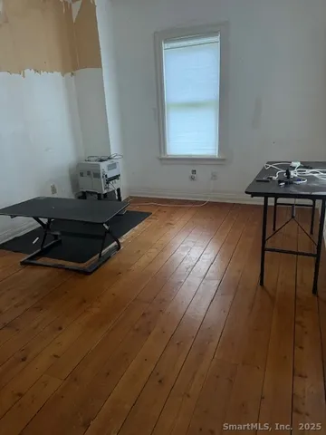 a living room with pool table chair and a wooden floor