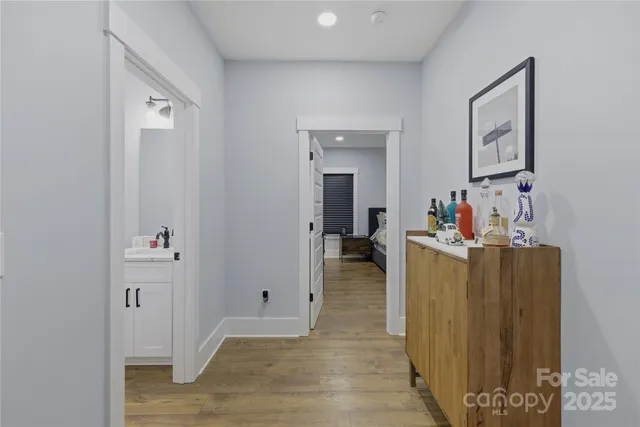 a view of a hallway with closet and wooden floor