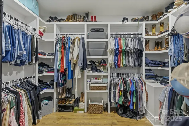 a view of walk in closet with clothes and shoes